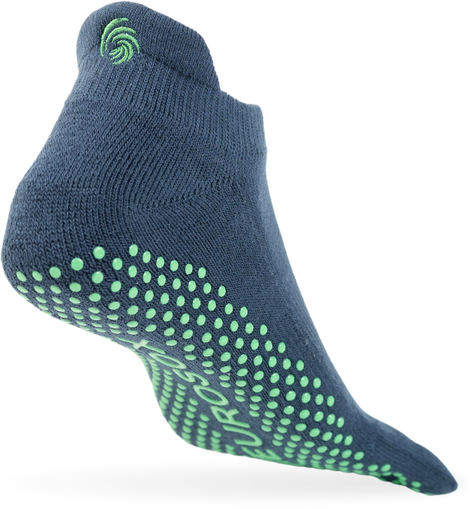 
                  
                    The image shows a single navy colored sock with green grip dots on the sole, positioned as if suspended in mid-air against a plain white background. The sock has a small green swirl logo near the ankle area.
                  
                