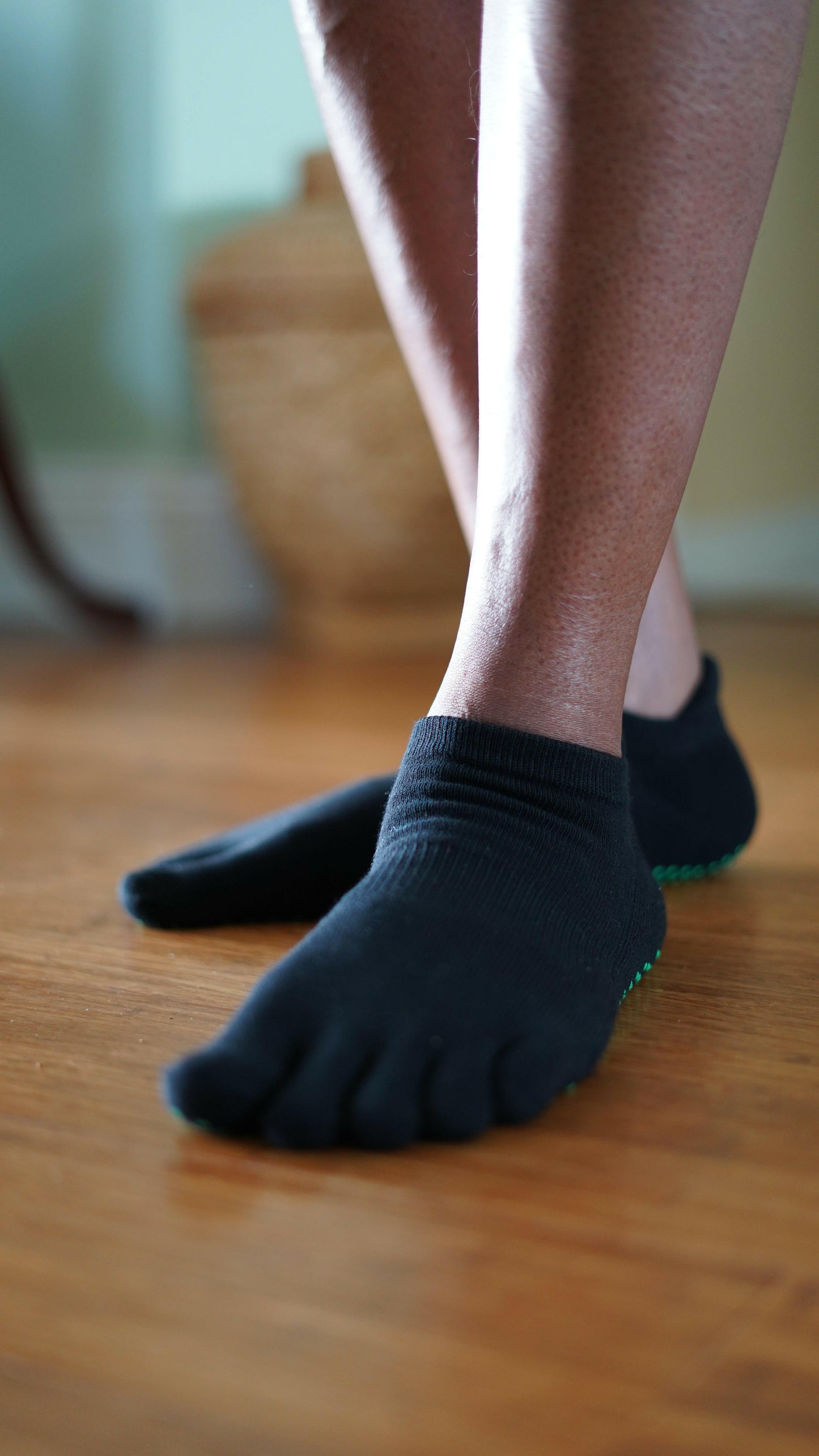 
                  
                    NeuroSox Five Toe Grip Sock worn indoors, showing snug toe fit and barefoot-style comfort on wood floor
                  
                